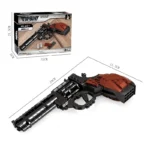 A toy revolver made of black and brown building blocks is displayed with its packaging.