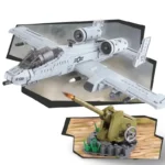 A gray toy airplane and a green toy cannon are displayed in the image.