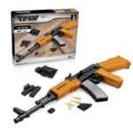 A toy assault rifle with orange and black pieces, along with some additional toy pieces and a box.