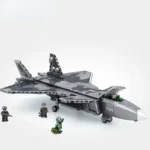 A gray and black camouflage toy jet is accompanied by four toy figures.