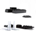 Black and white toy building blocks and bullet-shaped pieces are arranged on a surface.