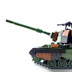 A toy tank with a long green barrel and a machine gun on top.