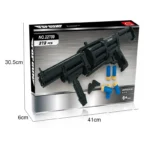 A black toy gun assembled from building blocks, along with blue and yellow toy ammunition, rests on a box.