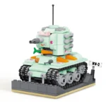 A light green toy tank with black treads and orange accents sits on a gray base.