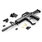 A black toy gun with several black building blocks and three yellow toy bullets.