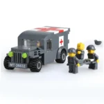 A gray toy ambulance truck with a red cross and three toy figures carrying a stretcher.