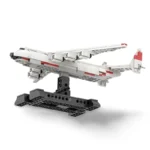 A white and red toy airplane model is displayed on a black stand.