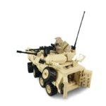 A tan brick toy military vehicle with six wheels, two figures and weapons.