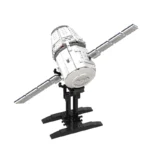 A white and gray space satellite model with two solar panels is mounted on a black stand.