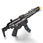 A toy gun made of black and silver construction blocks with blue pins and a gold tip is displayed.