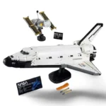A white and black space shuttle toy with a satellite and two black information cards.