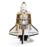 A toy space shuttle with solar panels and USA flag is shown from a top view.
