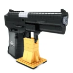 A black toy gun rests on a gold stand.