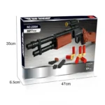 A toy gun with a scope, several red and gold shells, and some black pieces are displayed on a box.