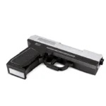 A toy gun made of black and silver bricks is on a white surface.