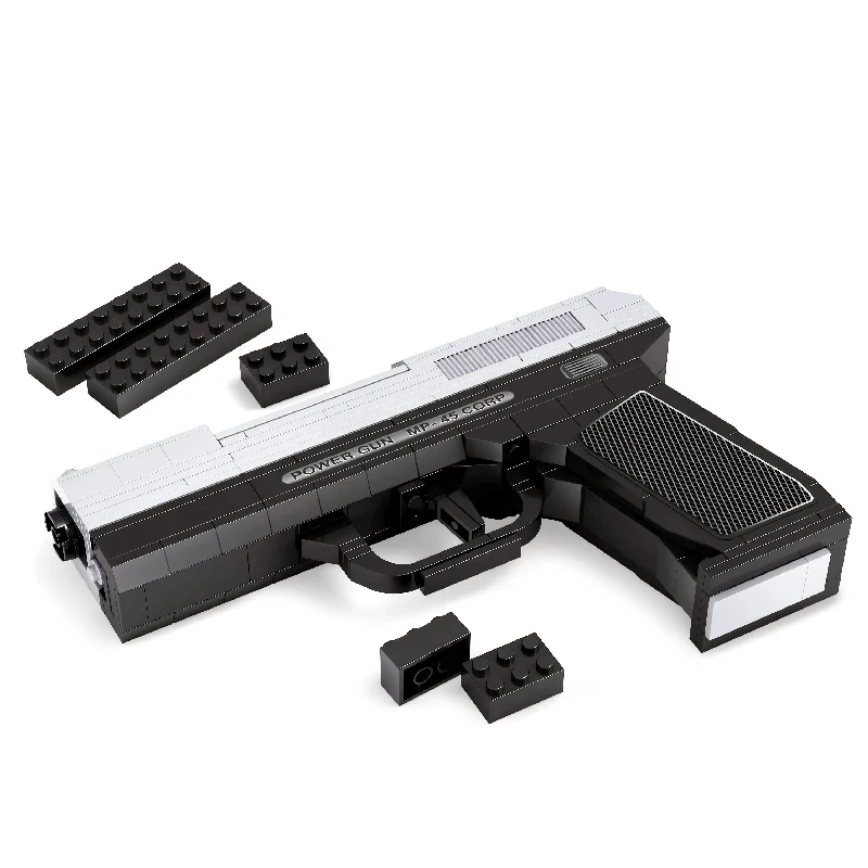 A toy gun made of black and silver blocks with several loose blocks nearby.