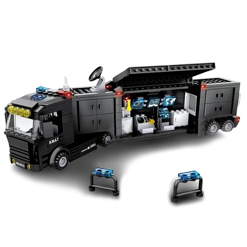A black toy truck with an opened side panel, revealing a control room with screens, and three small barriers.
