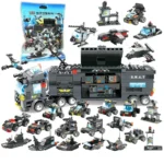 A collection of black and gray toy vehicles, including a large truck, helicopters, cars, and boats, are displayed.