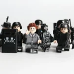 A group of toy figures includes one figure in a gray suit and several figures in black police uniforms, some holding weapons and a shield.