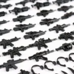 Black toy guns and accessories are arranged in rows.