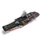 A toy aircraft carrier with a black deck, red accents, and several small gray planes.