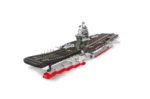 A toy aircraft carrier with a black flight deck, red accents, and gray structure is displayed.