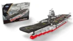 A brick toy aircraft carrier with a black deck, red hull, and gray accents is displayed next to its box.