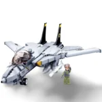 A gray toy jet with black tail fins and a small figure in a green uniform standing next to it.