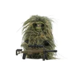 A toy figure wearing a ghillie suit holds a rifle with a scope and bipod.
