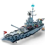 A gray toy warship with a cannon, missiles, a red flag, and a small vehicle.