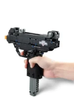 A hand holds a black brick toy gun with a gray magazine.