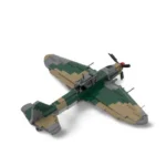 A toy airplane with green, tan, and gray blocks is displayed.