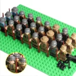 A group of toy soldiers with rifles and helmets stand on a green base plate, with a cannon and bullets nearby.