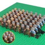 A group of toy soldiers with rifles and helmets stand on a green base, with a cannon and projectiles nearby.
